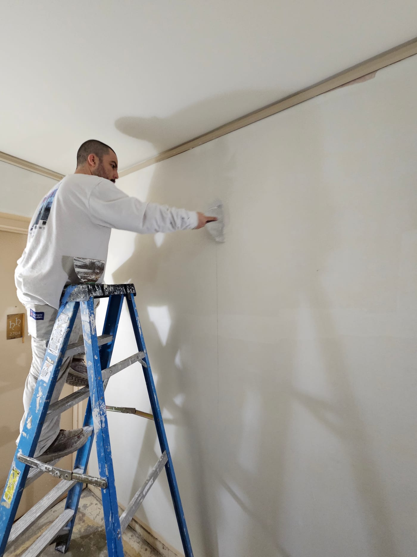 Painter Smoothing Ceiling On Scaffold - Drywall Repair by Z&Z Painting